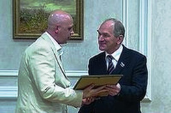 Председатель Заксобрания области Николай Воронин вручает Олегу Воронову сертификат "Меценат года"