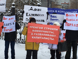 Участники митинга против беспредела «Роснефтегаза» прячут лица за плакатами