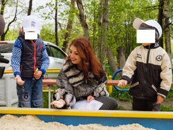 На детей, играющих в песочнице, надели кепки с символикой «Единой России»