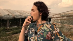 В видеоролике актриса прогуливается между теплицами и поедает огурцы