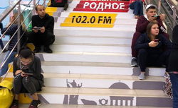 Пассажирам не хватает скамеек, люди сидят на ступеньках лестницы