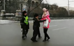 Женщине с ребенком на плечах не разрешили пересечь дорогу и пройти к театру
