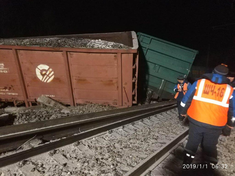 Сошедшие с путей вагоны и сотрудники железной дороги