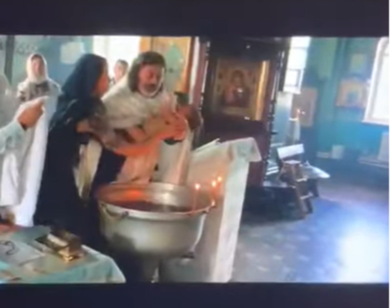Священник не отдает матери сына, продолжая обряд