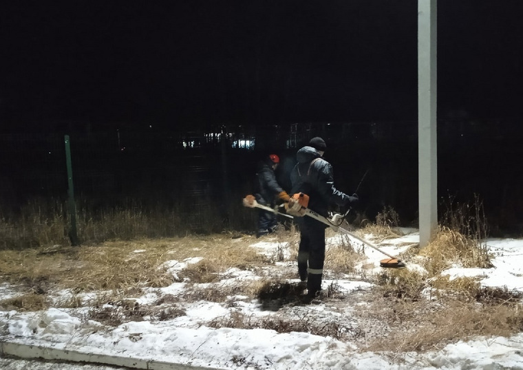 Рабочие «Сибура» с мотокосилками боролись с зарослями травы на территории предприятия в -20
