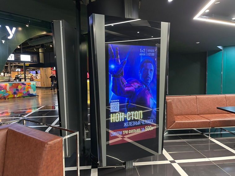 В холле кинотеатра есть афиша о нон-стоп показе «Железного человека»
