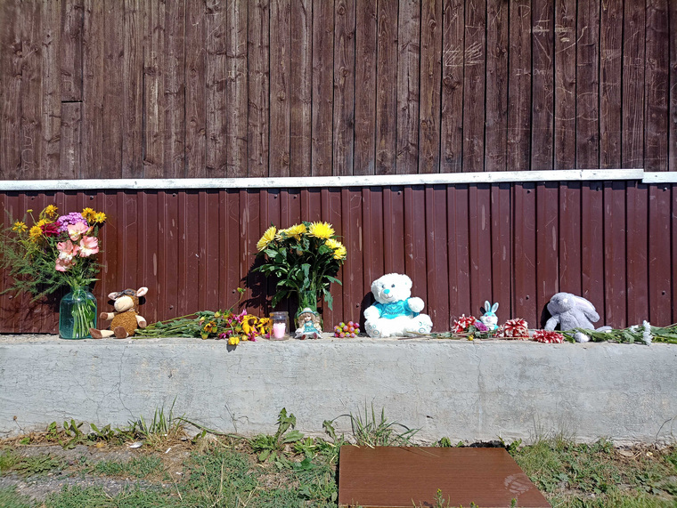 Жители поселка приносят к месту трагедии игрушки и цветы