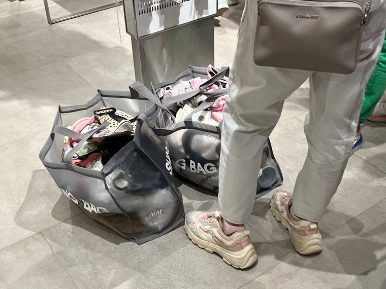 Посетители магазина набирают в примерочную сумки