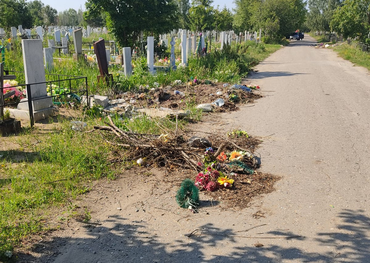 Сухие ветки, трава и пластик лежат рядом с могилами
