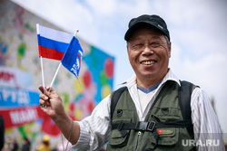 Первомайская демонстрация в Москве на Красной площади. Москва, улыбка, российский флаг, азиат, китаец, триколор, российско-китайская дружба, китайский турист, туризм