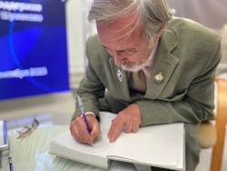 Заслуженный геолог Югры Сергей Комарицкий ставит автограф на своей новой книге