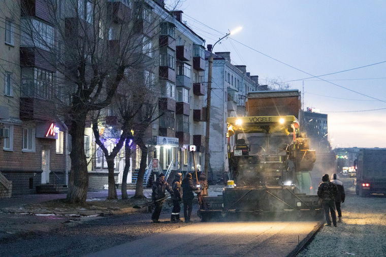 На месте раскопки работает асфальтоукладчик и катки