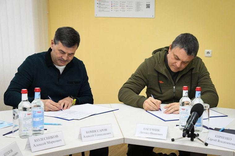Леонид Пасечник подписывает документы с Алексеем Комиссаровым