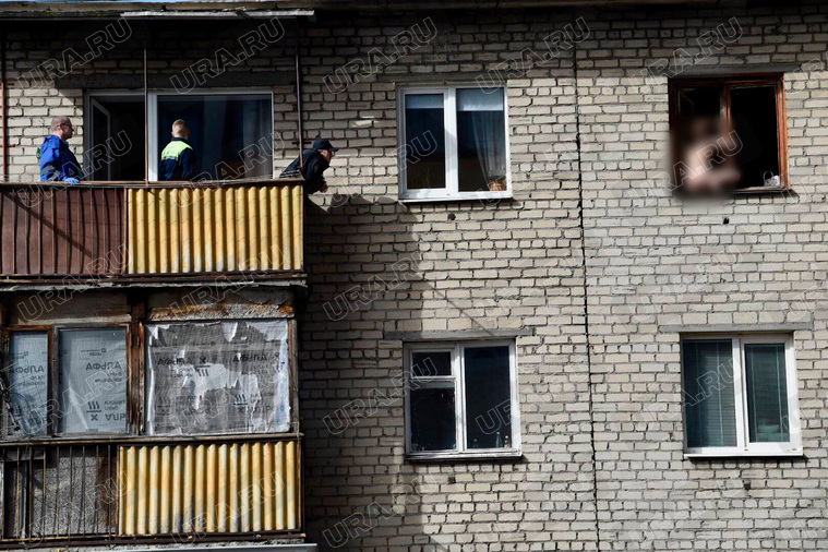 Спасатели уговаривают женщину зайти в квартиру