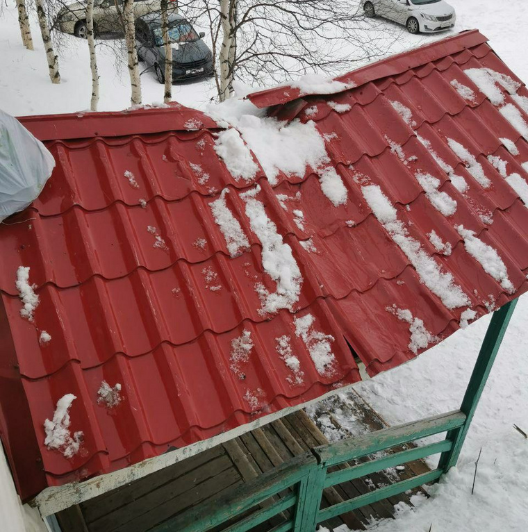 Козырек подъезда повредила сошедшая с крыши глыба снега