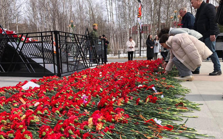 Жители Нижневартовска несут цветы к мемориалу у парка Победы