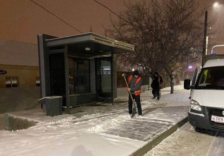 Рабочие убирали снег с остановок ночью