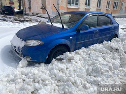 Дорожники присыпали машину снегом при уборке дороги